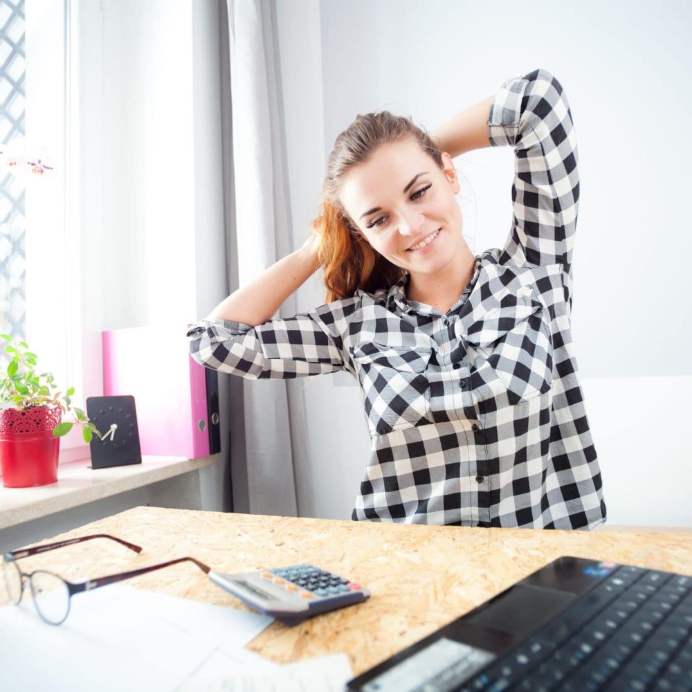 Young smiling woman finishing work in home office
